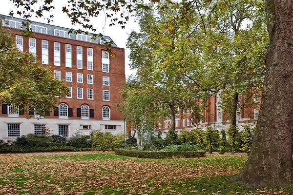 Tavistock Square in central Lonon, a leafy, grassy area with Woburn Hall in the background.